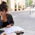 Traveler reviewing and marking up a draft itinerary at a café table